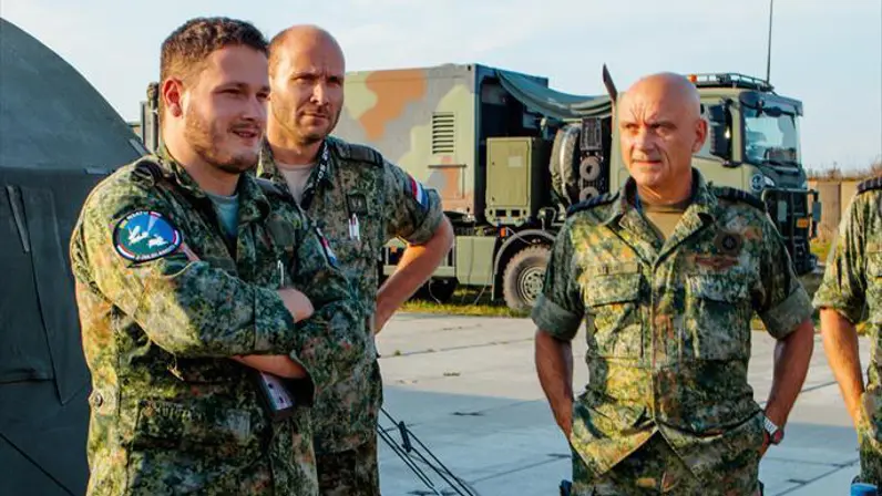 De Commandant Lucht- en Ruimtestrijdkrachten omringd door collega’s.