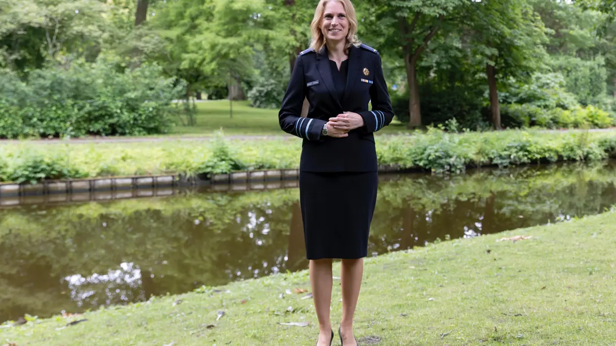 Luitenant-generaal Elanor Boekholt-O’Sullivan poseert in luchtmachtjurk met jasje in parkachtige omgeving.