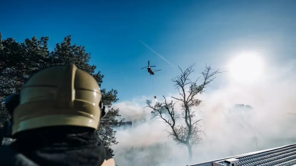 Blushelikopter vliegt boven brand.