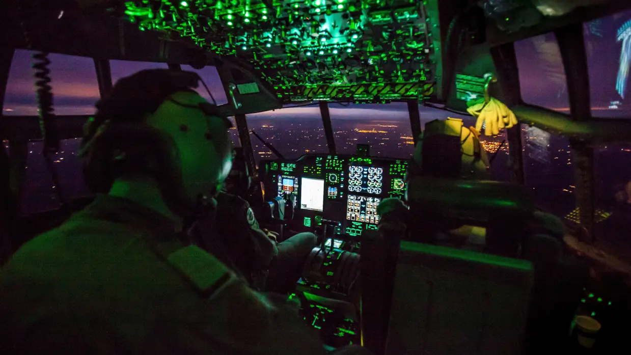 Cockpit van militair vliegtuig bij avond.