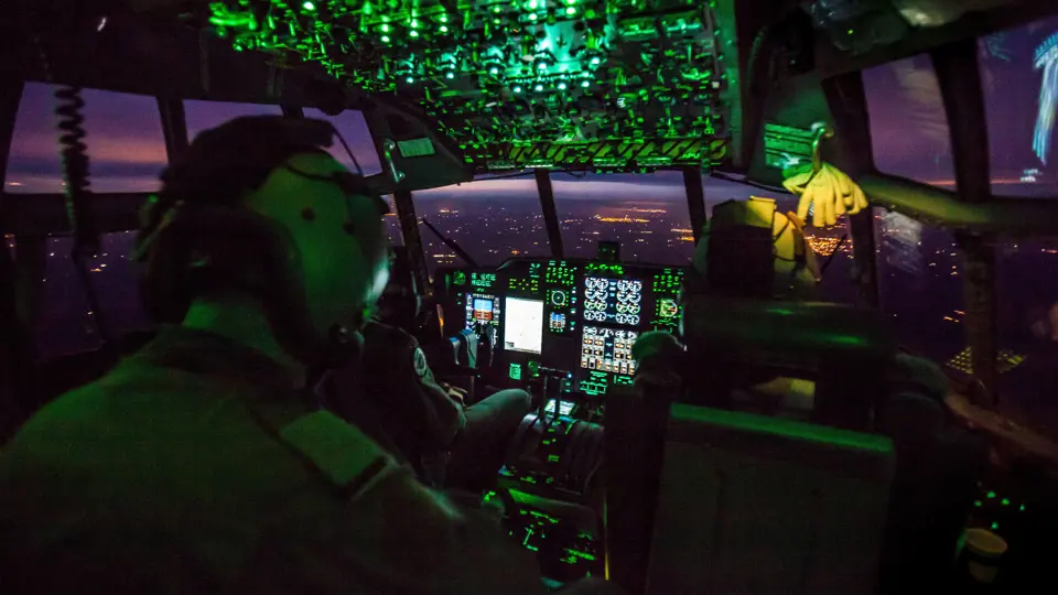 Cockpit van militair vliegtuig bij avond.