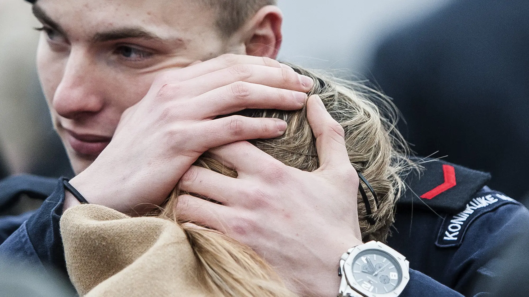 Militair houdt hoofd geliefde vast tegen zijn schouder.