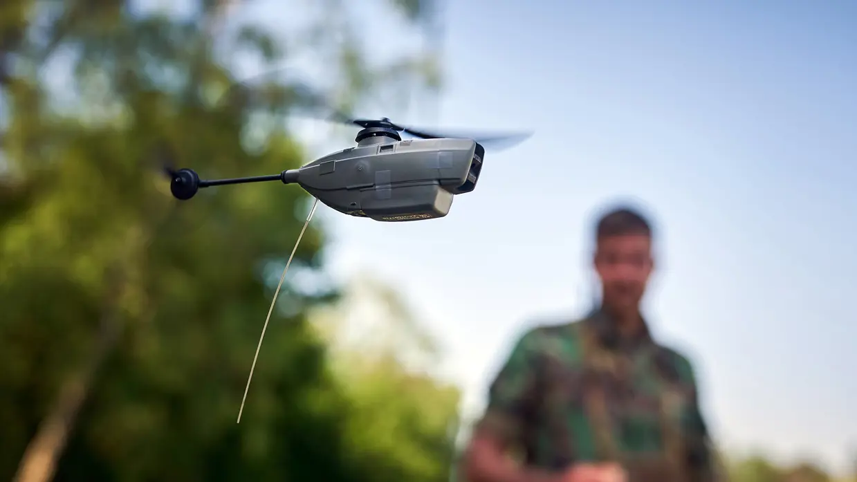 Een militair met op de voorgrond een Black Hornet.