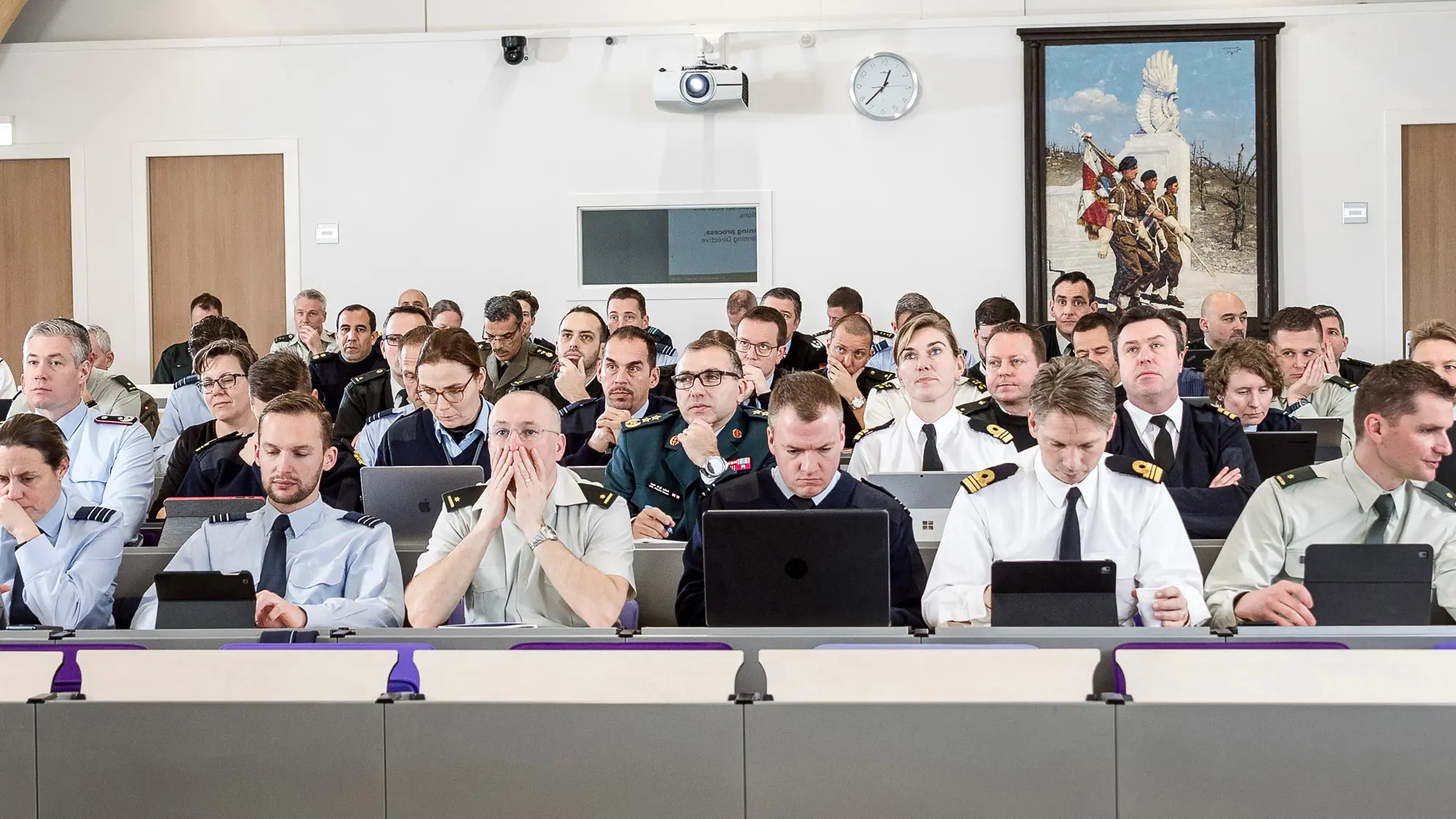 Docent op de rug gezien met voor hem een lokaal vol cursisten.