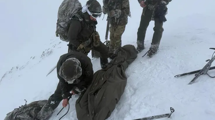 De mariniers in de weer met touwen en een slaapzakhoes. 