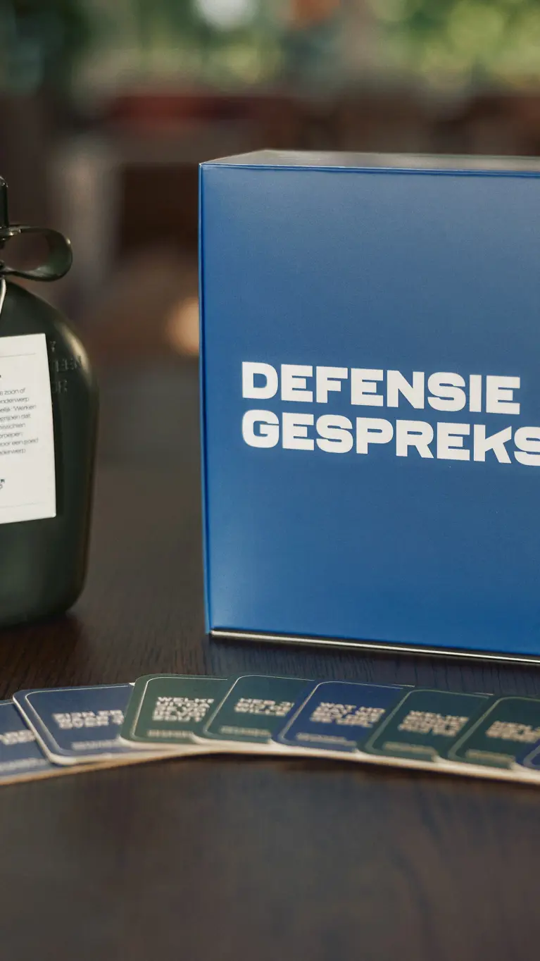 Veldfles en pc-scherm met daarop de tekst: Defensie Gespreksstarter.
