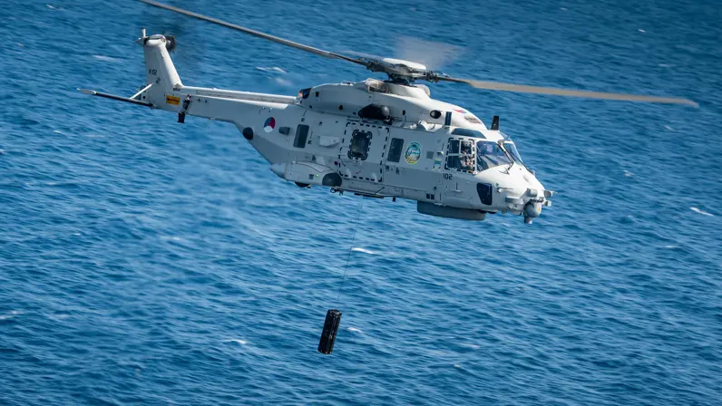 Een NH90 boven zee met eronder de dipping sonar.