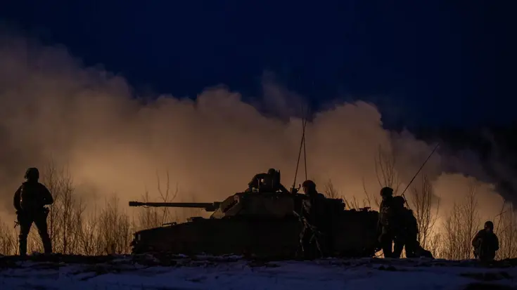 Tank en militairen in het donker.