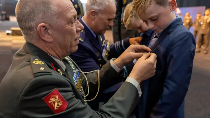 Kind krijgt medaille opgespeld.