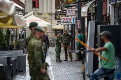 Militairen op straat in gesprek met lokale bevolking.