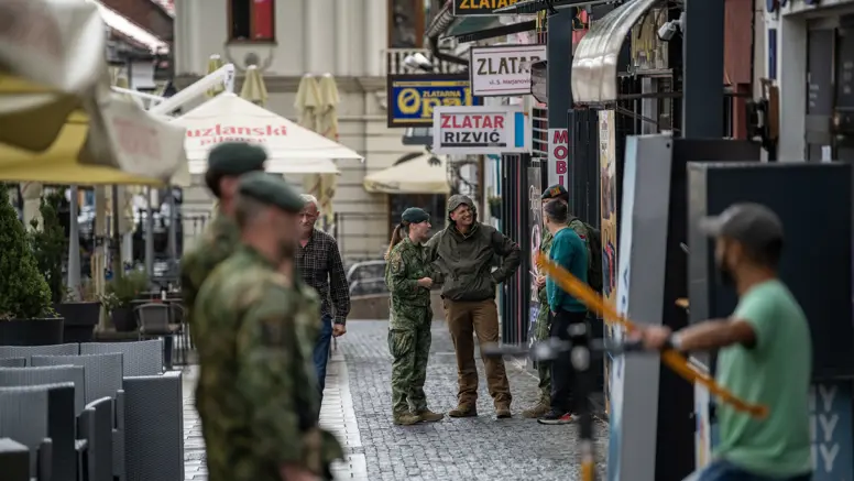 Militairen op straat in gesprek met lokale bevolking.