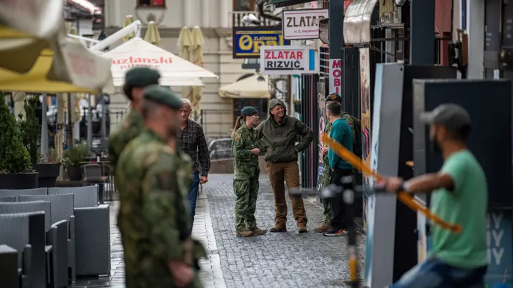 Militairen op straat in gesprek met lokale bevolking.