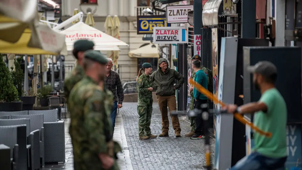 Militairen op straat in gesprek met lokale bevolking.