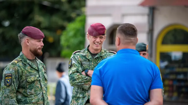 Militairen op straat in gesprek met lokale bevolking.