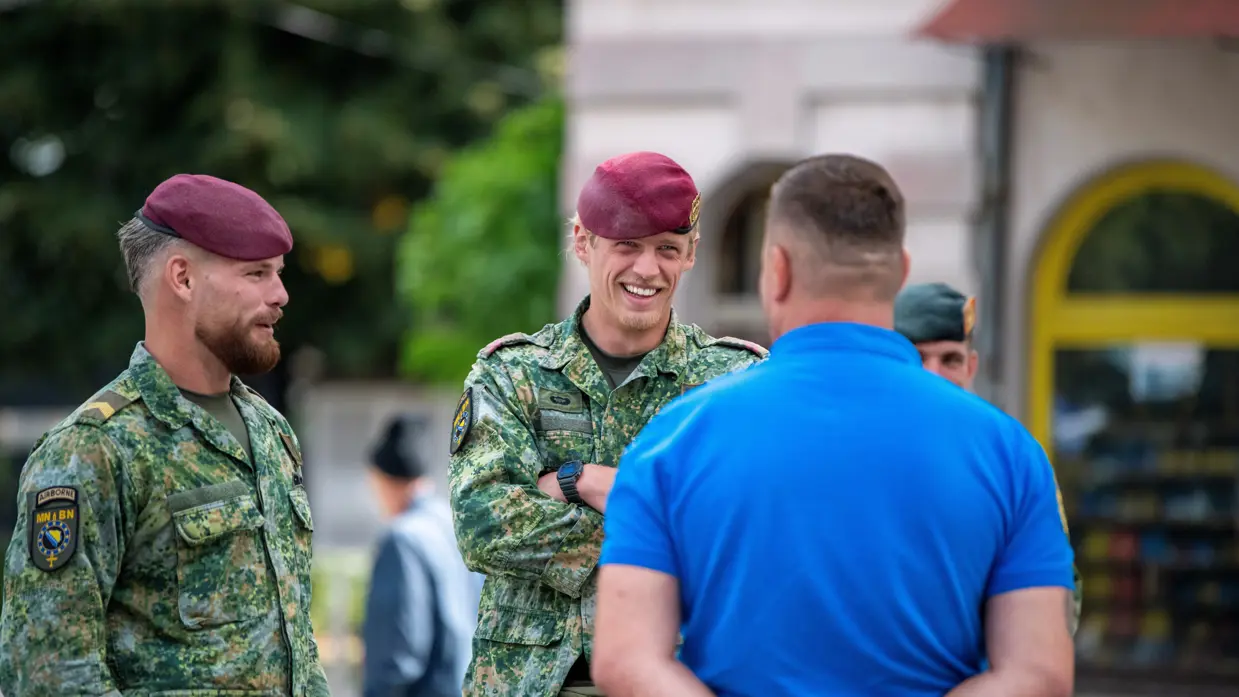 Militairen op straat in gesprek met lokale bevolking.