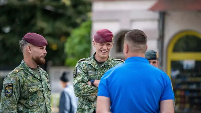 Militairen op straat in gesprek met lokale bevolking.