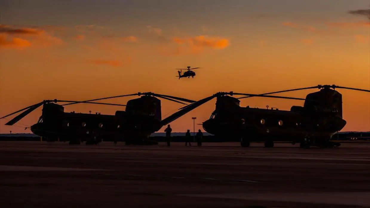 Twee Chinooks tegen het rode ondergaande zon.