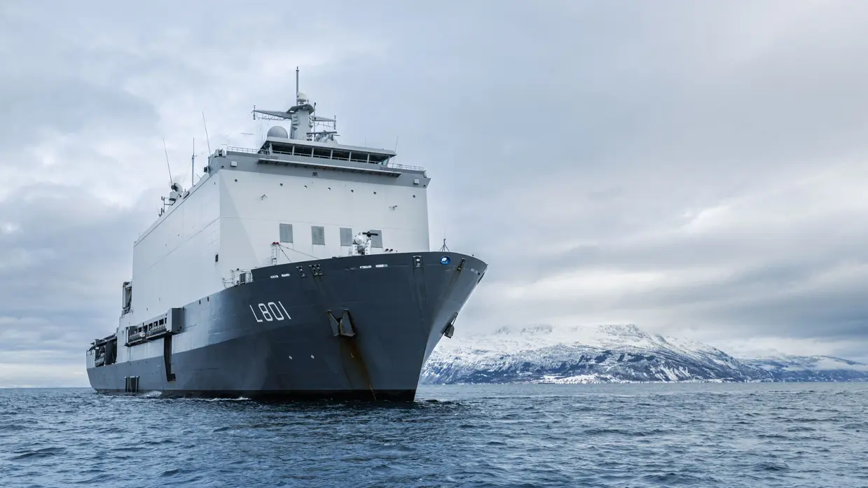 Vooraanzicht van Zr.Ms. Johan de Witt tegen de achtergrond van de Noorse kust.