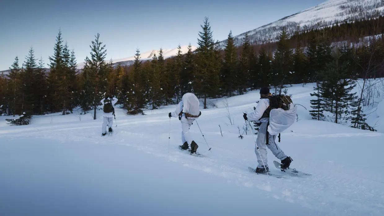 Drie mariniers verplaatsen zich op ski’s in een Noors sneeuwlandschap. &nbsp; &nbsp;
