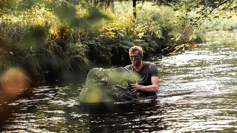 een reservist in het water met een drijfpakket.