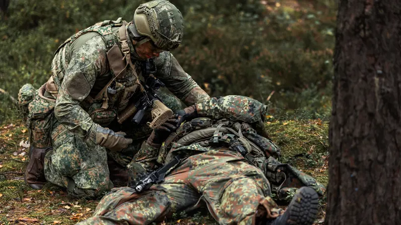 een militair die een gewonde behandelt.