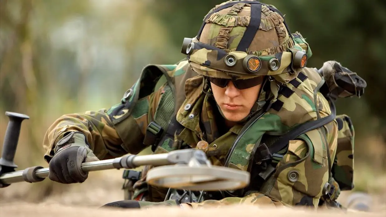 Een militair aan de slag met een metaaldetector.