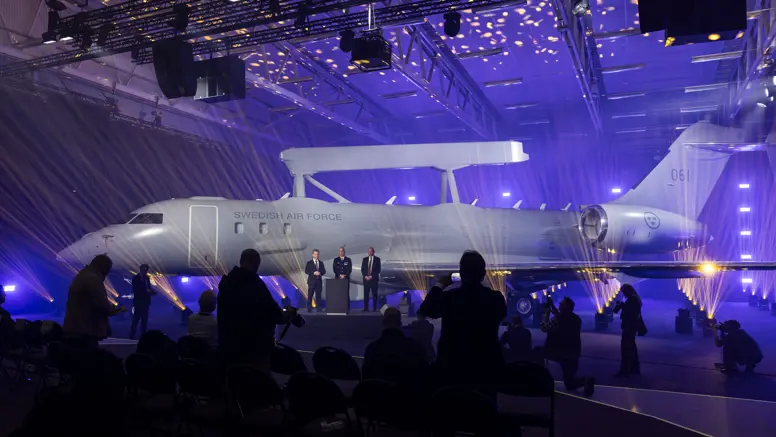 Onthulling van de eerste Zweedse Saab GlobalEye in een hangar met paars gekleurde lampen.