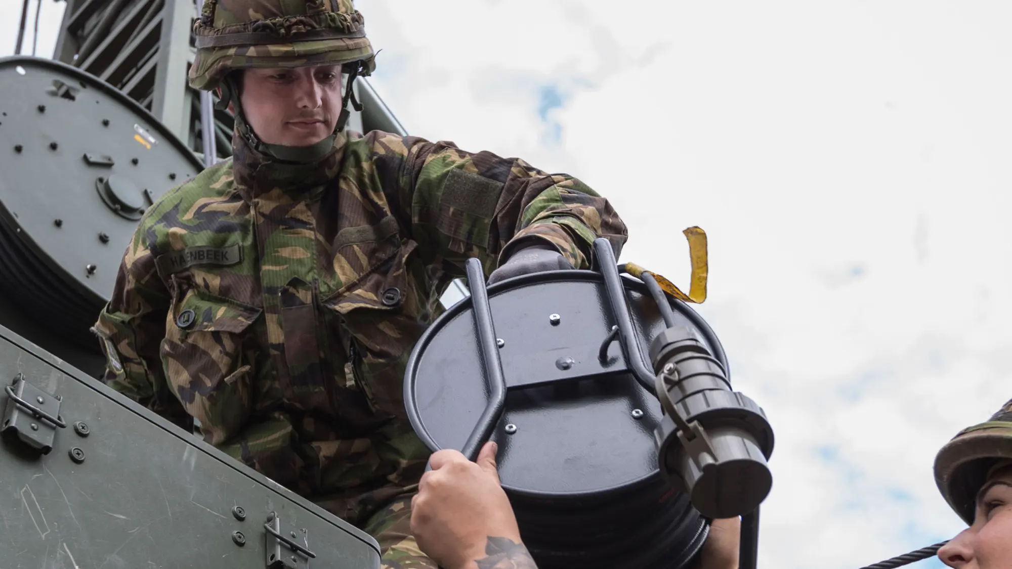 Militair geeft andere militair verlengsnoer aan.