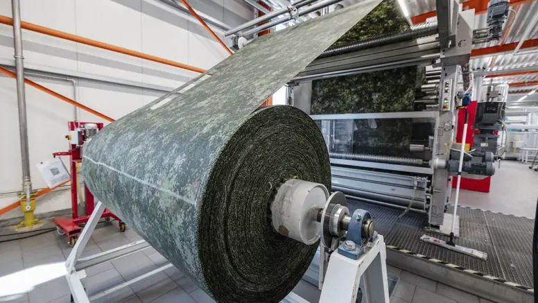 Rol militaire stof op een machine