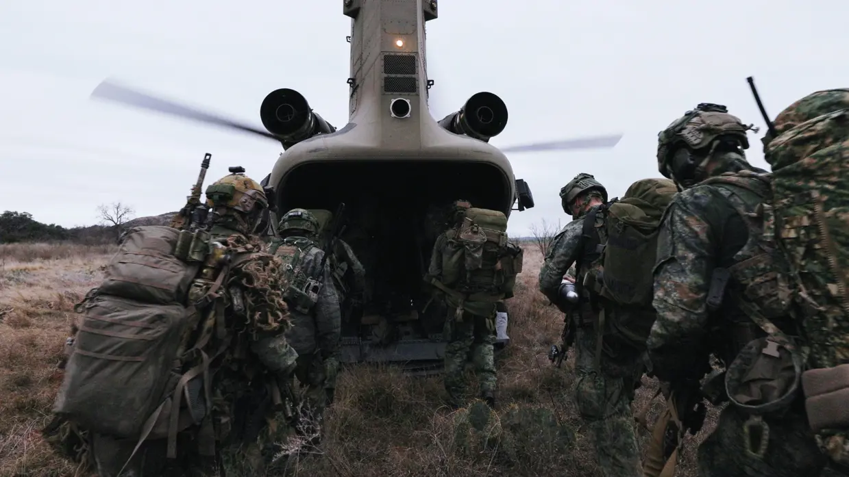 Militairen in het veld stijgen een Chinook in.
