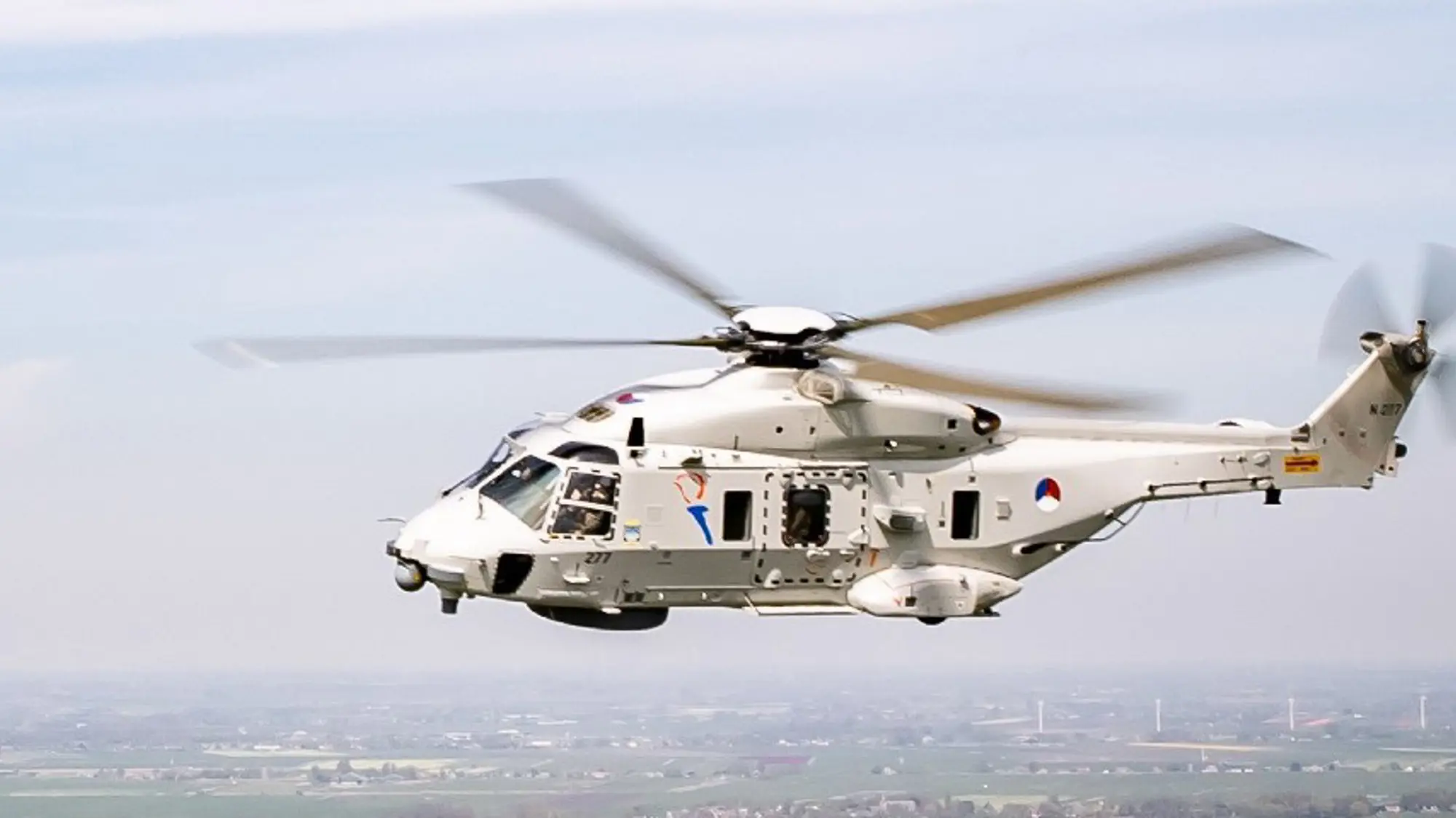 NH90-maritieme gevechtshelikopter vliegt boven land.
