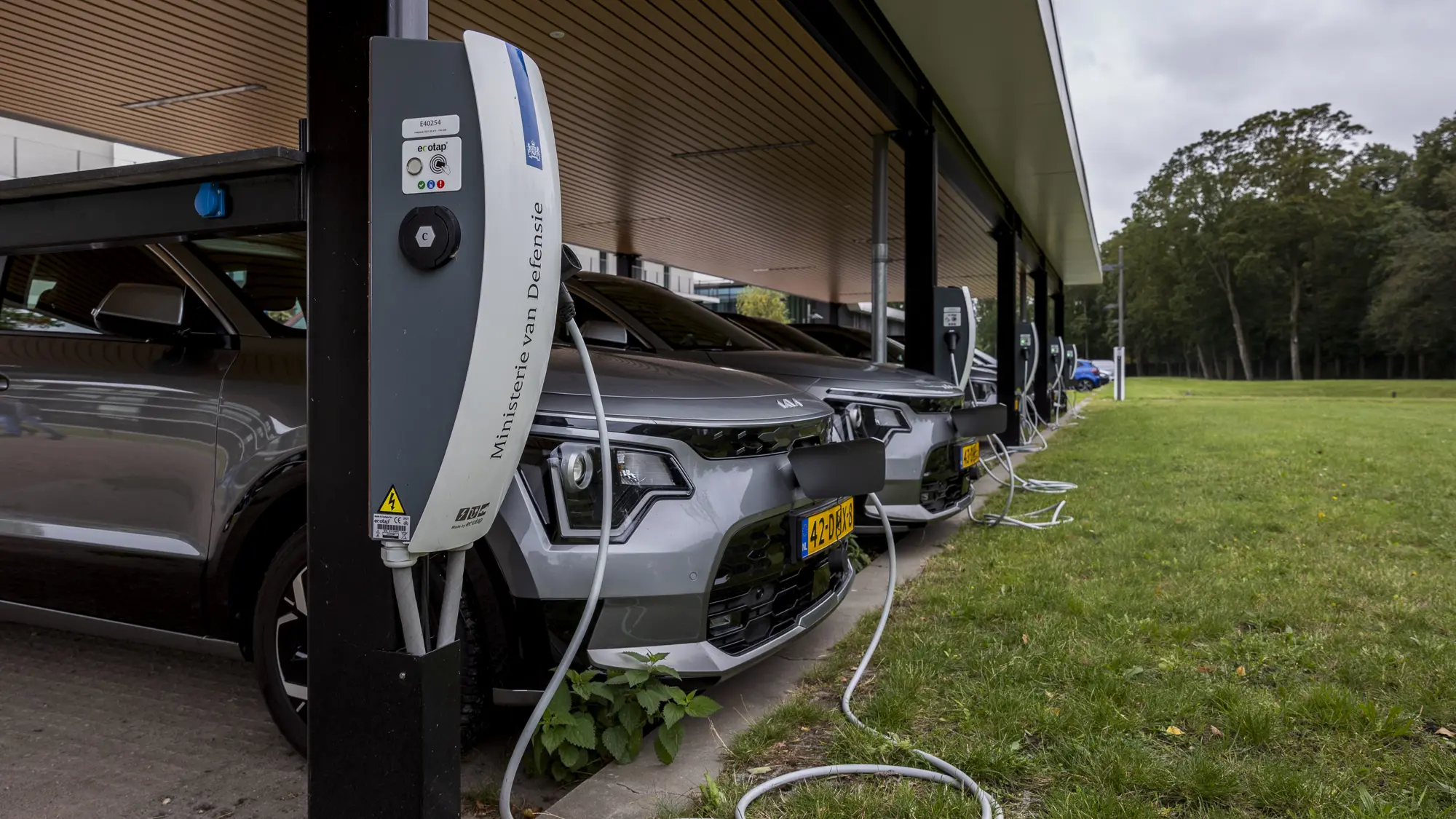 Afbeelding van wieken van een transporthelikopter en op de achtergrond die van een windmolen.