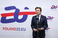 Minister Brekelmans voor een wit bord met blauwe en rode tekst: EU Poland25.EU