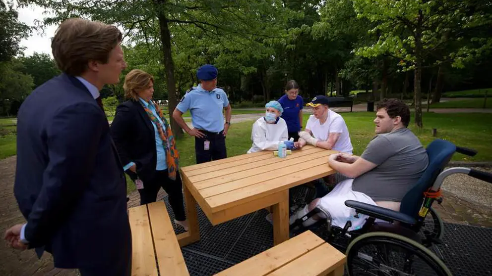De minister in gesprek met revaliderende militairen.