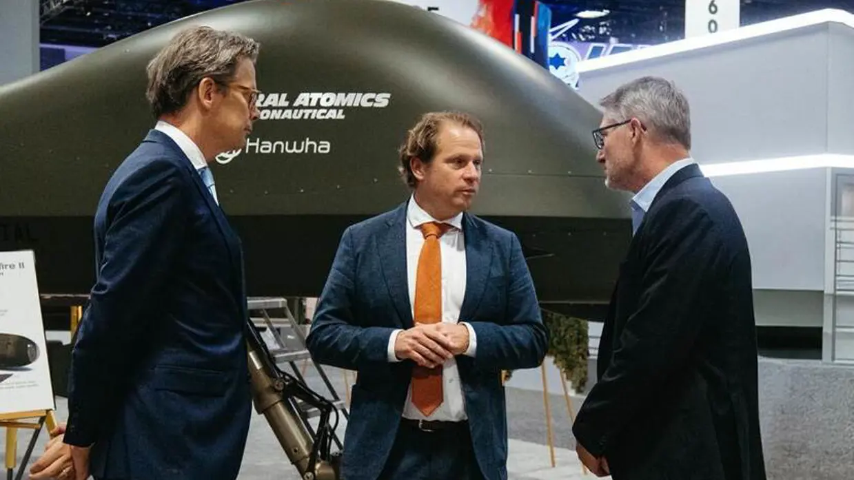 Staatssecretaris Tuinman in gesprek met 2 mannen.