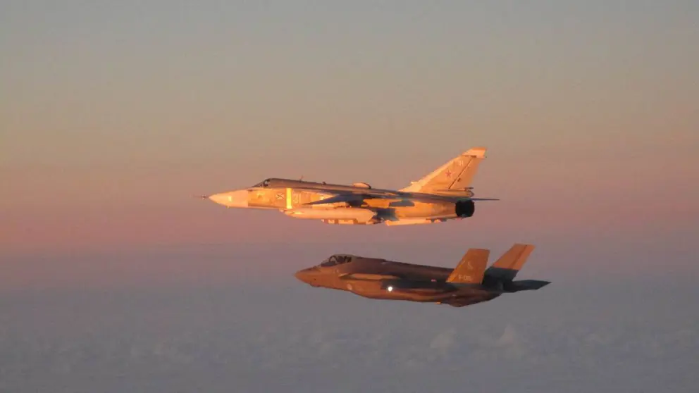 F-35 begeleidt een Russisch vliegtuig in de lucht.