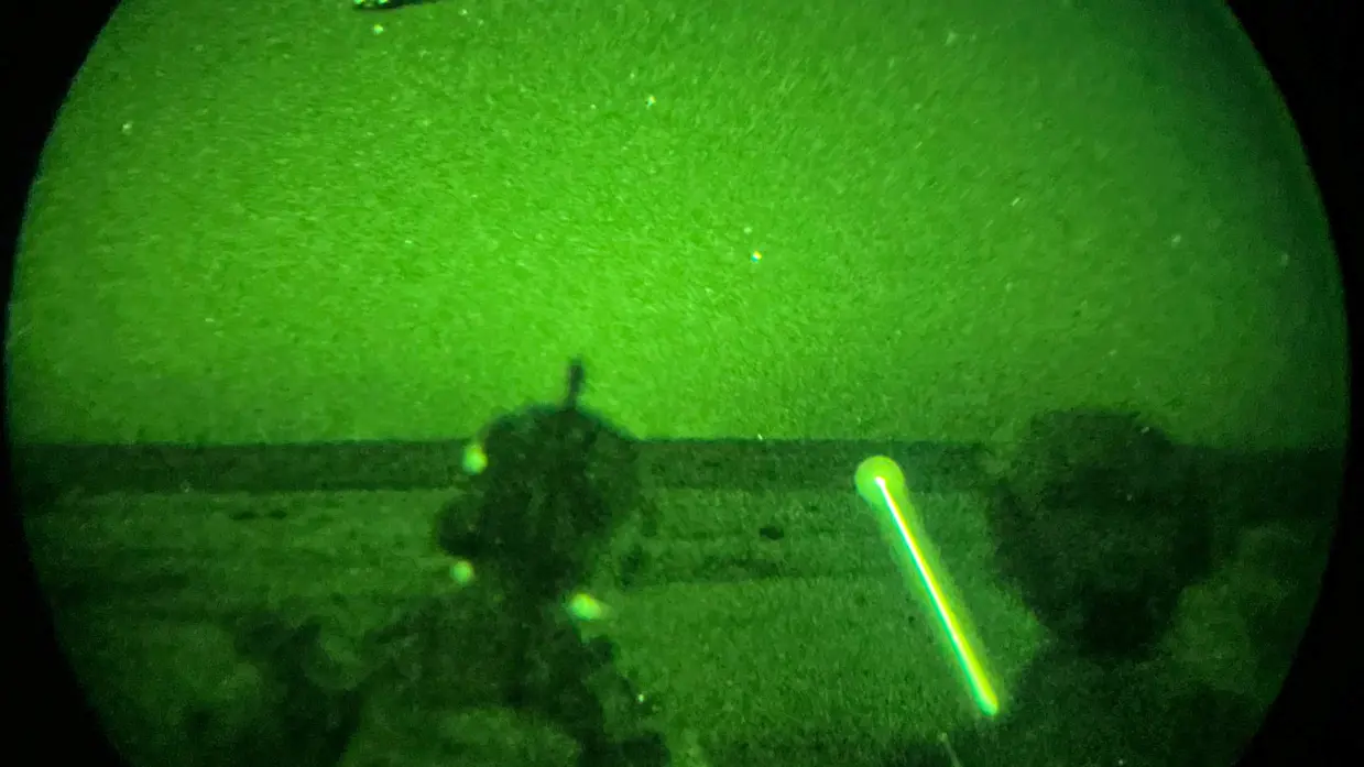 Foto’s van de Live Fire-oefening door een nachtkijker genomen waarbij vanuit een helikopter wordt geschoten.