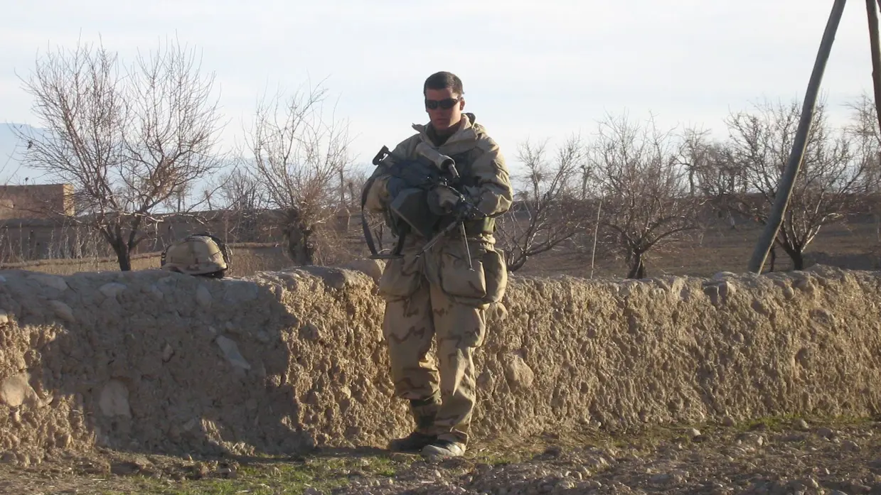 Een soldaat in Afghanistan, met een licht machinegeweer op de man.