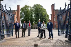 De ondertekenaars staan tussen de poorten van de kazerne. 