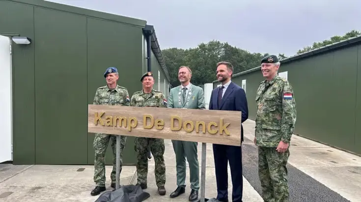 Mensen met het nieuwe naambord op Kamp Dongen.