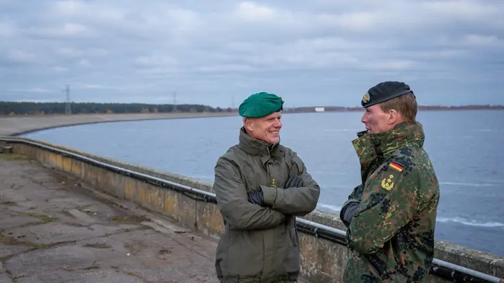 Christian Freuding en Jan Swillens met elkaar in gesprek aan de rand van een meer.
