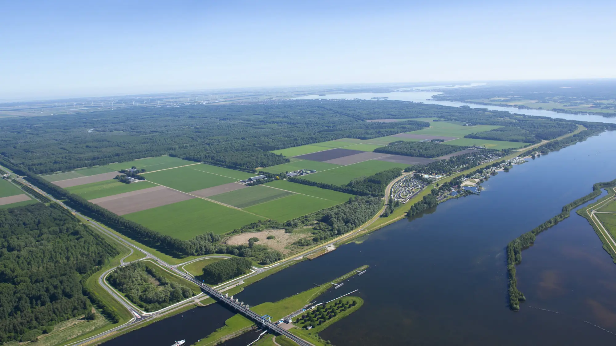 Luchtfoto van Zeewolde met water, weilanden en bomen.