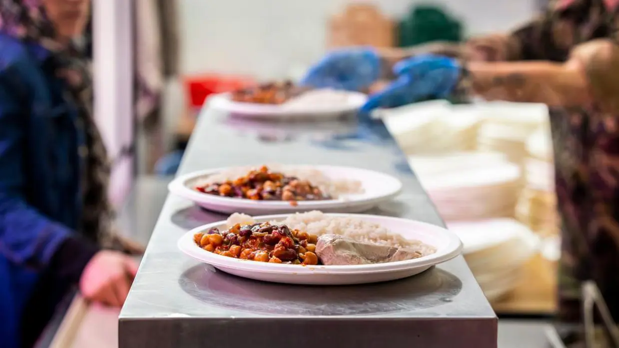Borden met chili con carne staan klaar op een uitgiftepunt.