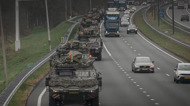 Militaire colonne rijdt over snelweg.