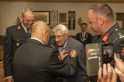 Een veteraan krijgt een medaille opgespeld.