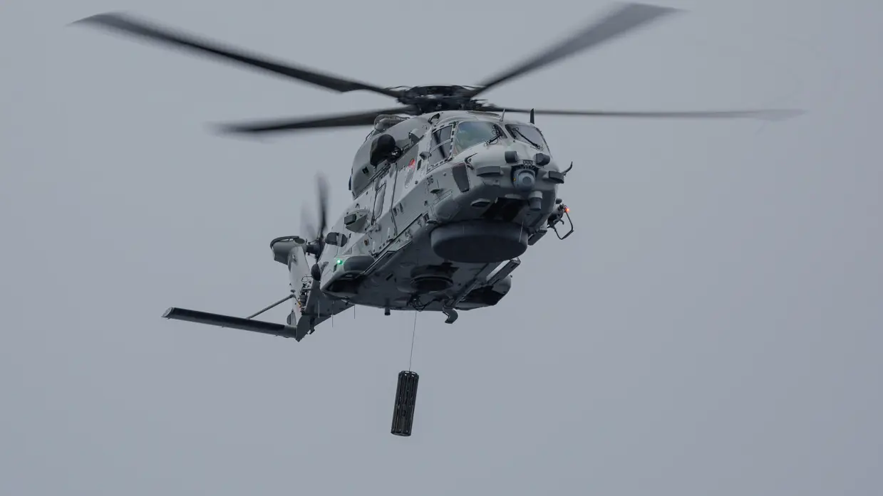 Een NH90-helikopter met daaronder de Long-Range Active Sonar.