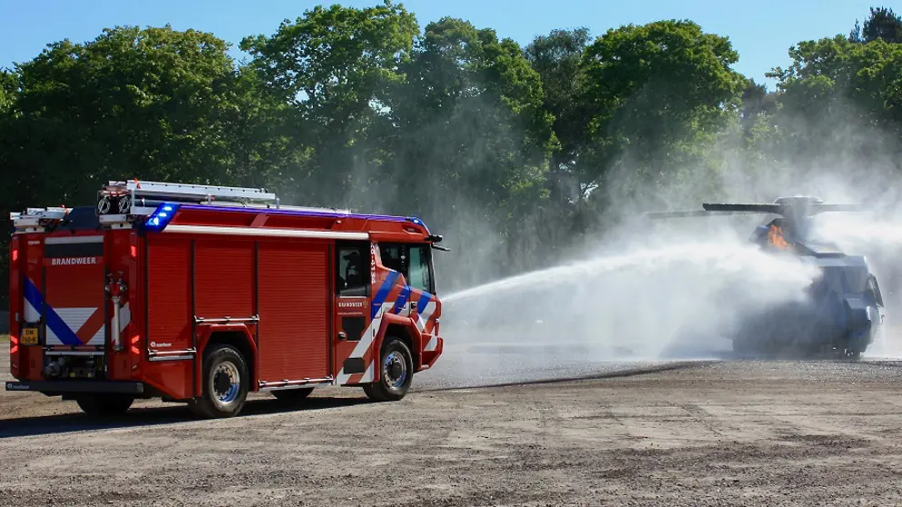 Een brandweerwagen blust.