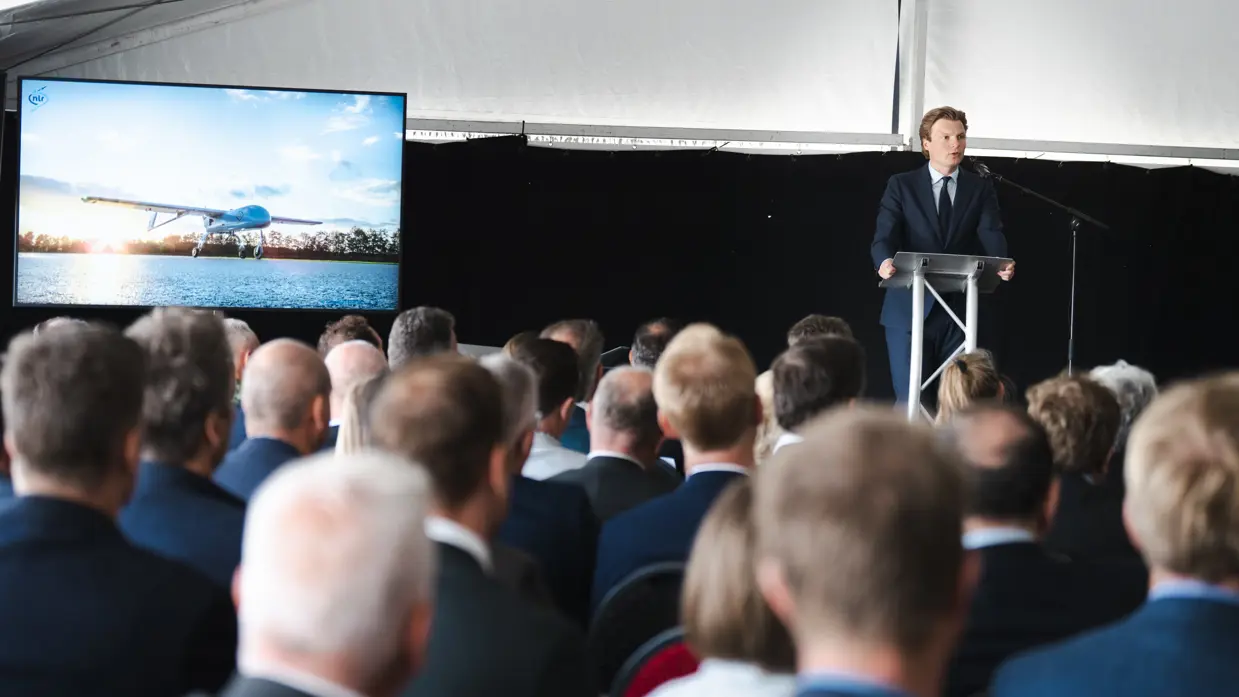 De minister speecht tijdens een evenement.