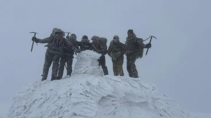 De mariniers staan op de top van de berg. 