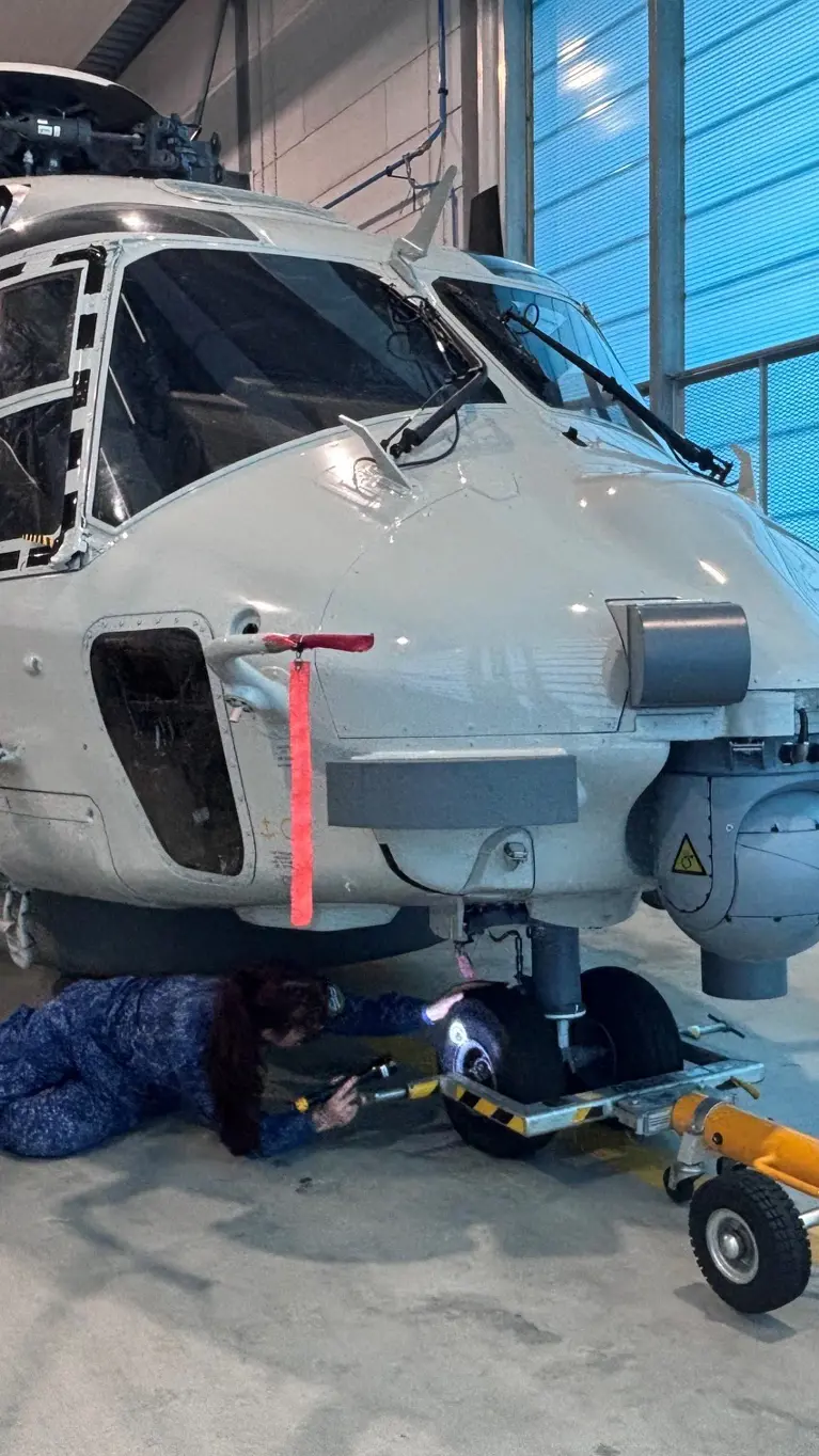 Matroos 1 Technische Dienst Jaimie inspecteert het neuswiel van een NH90.